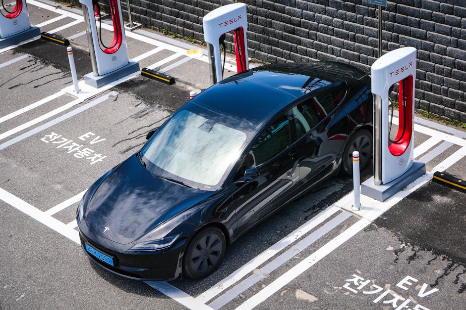A black Tesla parked at a charging station in an urban setting